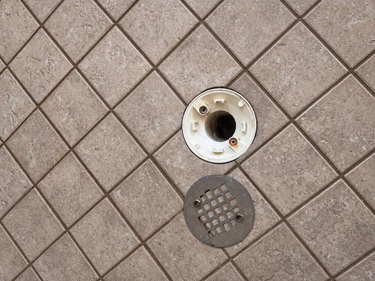 The same shower drain and surrounding tile left spotless after cleaning